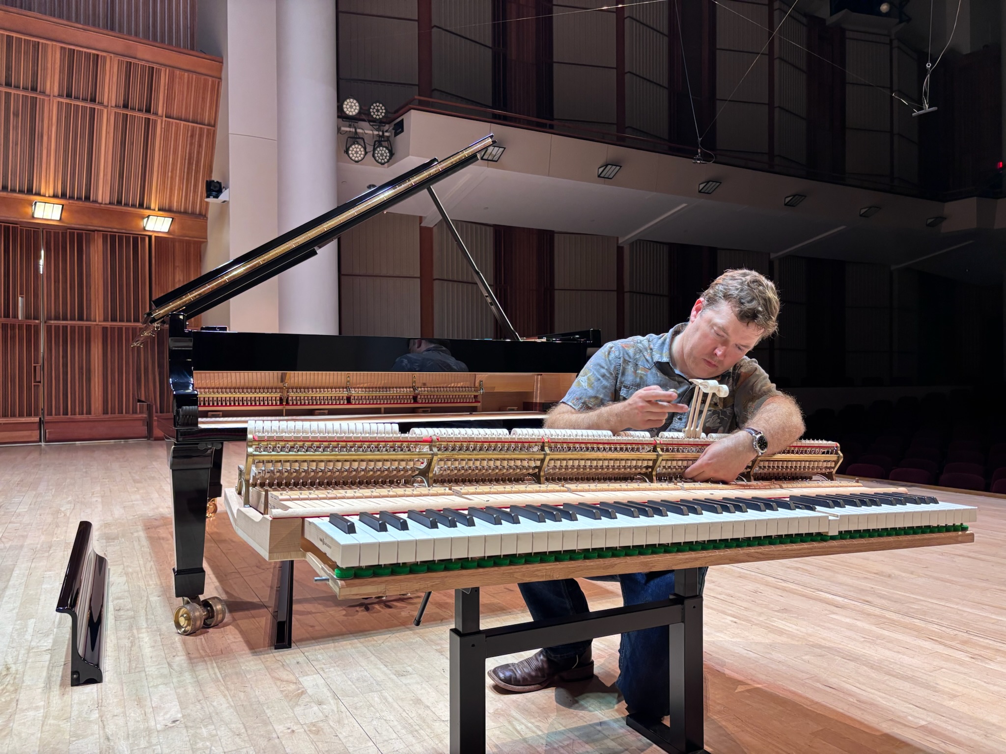 Brian Turano regulating a grand piano action at Ball State University